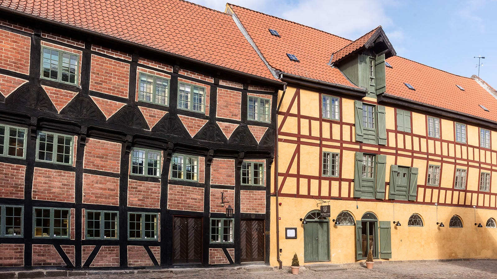 Ud over stenhuset mod gaden har Oluf Bagers Gård også et bindingsværkshus og en magasinbygning som baghuse.