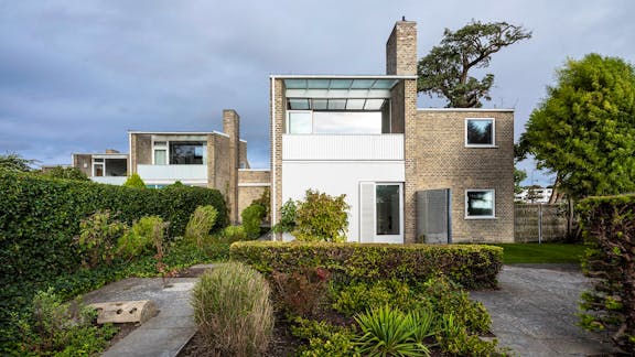 Facaden af huset set fra haven. Huset er bygget i grågul mursten med mørtel blandet med sand fra stranden. Gavlen mod haven er pudset med kalkpuds og derefter malet hvid.