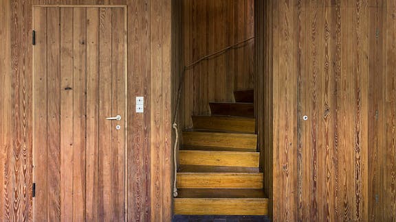 Trappen til første sal. Væggen er beklædt med sandblæst, knastfrit svensk fyrretræ.