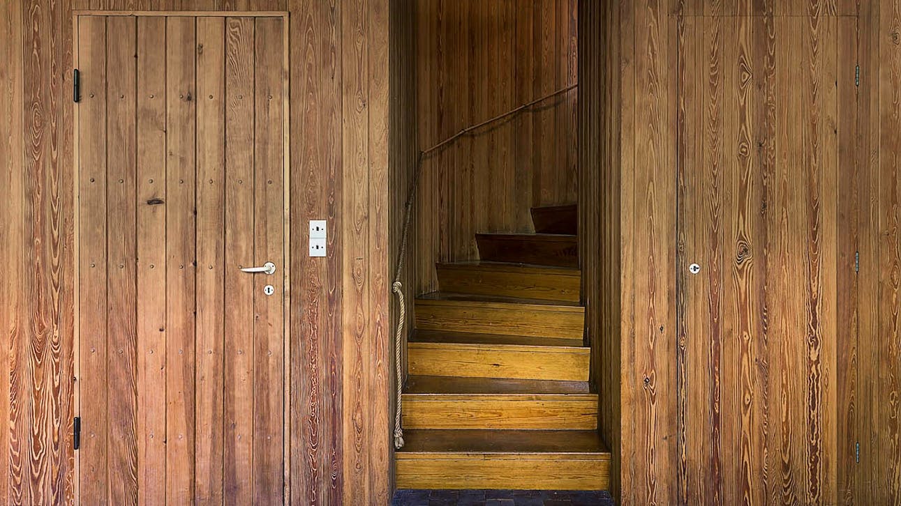 Trappen til første sal. Væggen er beklædt med sandblæst, knastfrit svensk fyrretræ.