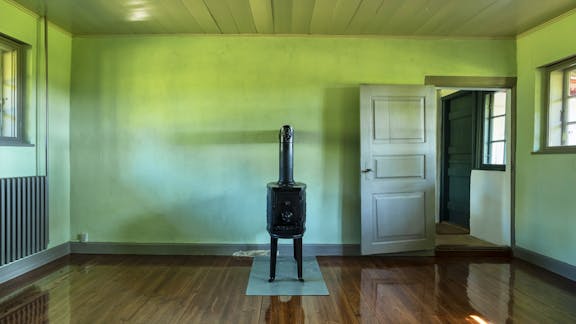 Dagligstuen med brændeovn og kig til køkkenet.