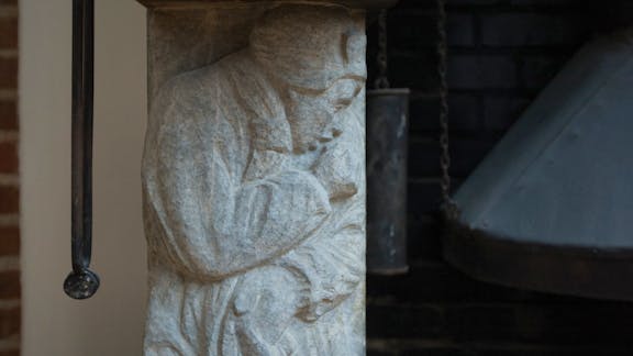 Pejsen i lille atelier er flankeret af to 'frysende koner'. 