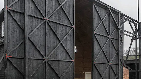 Ballonhangarens front med de store sorte træporte åbnet en lille smule.