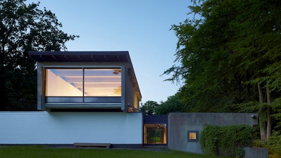 Knud Friis’ eget hus set om aftenen, beliggende på en naturskøn grund i Brabrand, Aarhus.