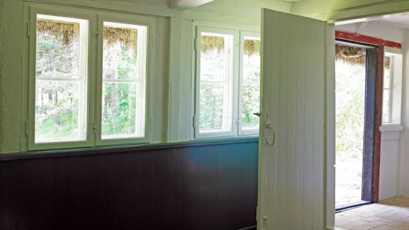 Den ene stue med adgang til køkken og udgang mod hustes sydside.