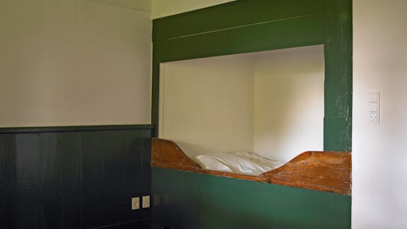 Alkove med grøn ramme og trædetaljer i Kalines tanghus på Læsø.