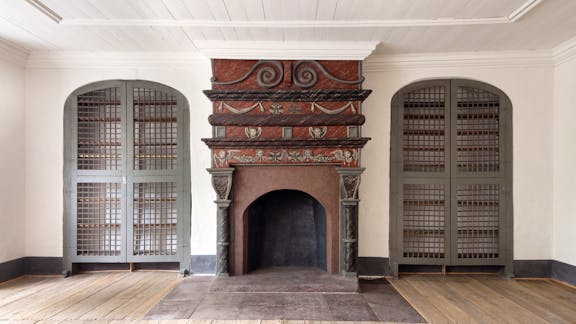 Karan Brahes berømte bibliotek stod i disse indbyggede reoler. Pejsen fremstår med renæssancebemaling og er fra kongens tid som ejer af huset.