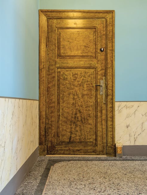 Ådret dør med marmoreret væg og terrazzo-gulv i Marskgården i Højer.