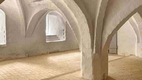 I kælderen ses spor fra bygningens ældste del. De spidsbuede hvælv var en del af bispegården.