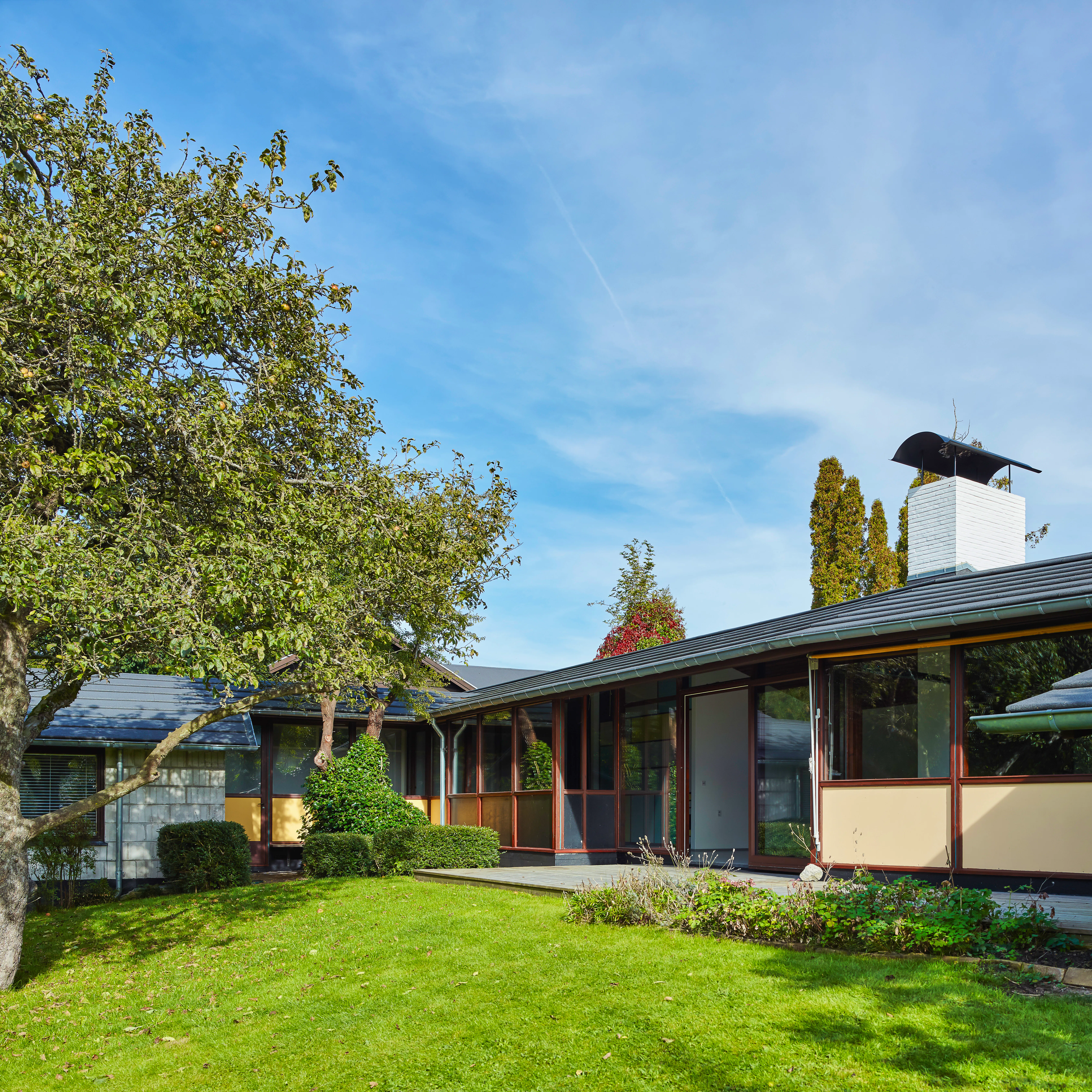 Husets facade mod haven og Hundesømosen er markant anderledes end mod vejen. Clemmensens hus er orienteret mod solen og underordner sig grundens fald mod mosen og samtidig Solbakkevejs sving.