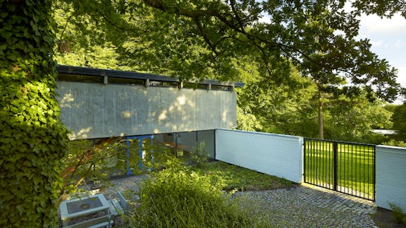 Gårdarealet er i forbindelse  med restaureringen eftergået  i belægninger og beplantning,  så det fremstår med sin oprindelige stramhed som en del af  arkitekturens helhed.