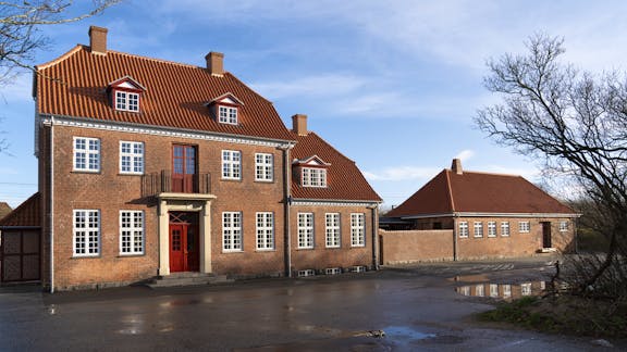 "Hel facade af Gelsted Station med røde tegltage, dannebrogsvinduer.