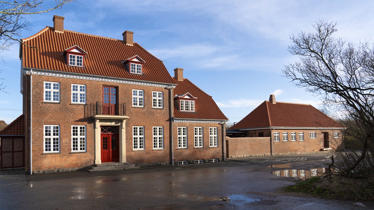"Hel facade af Gelsted Station med røde tegltage, dannebrogsvinduer.