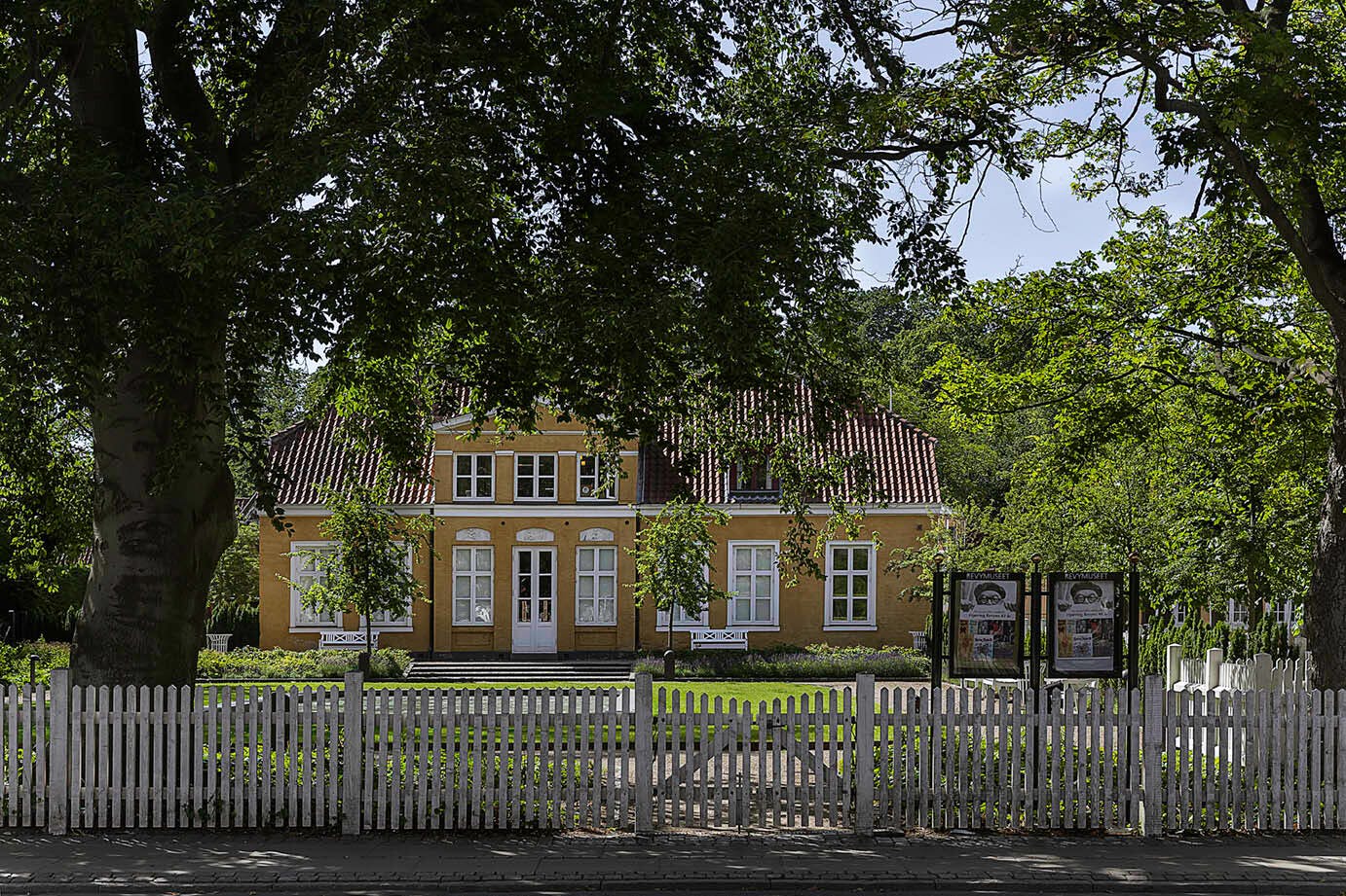 Riises Landsted repræsenterer den oprindelige bebyggelse langs Allegade på Frederiksberg med have foran huset afgrænset af et hvidt stakit.