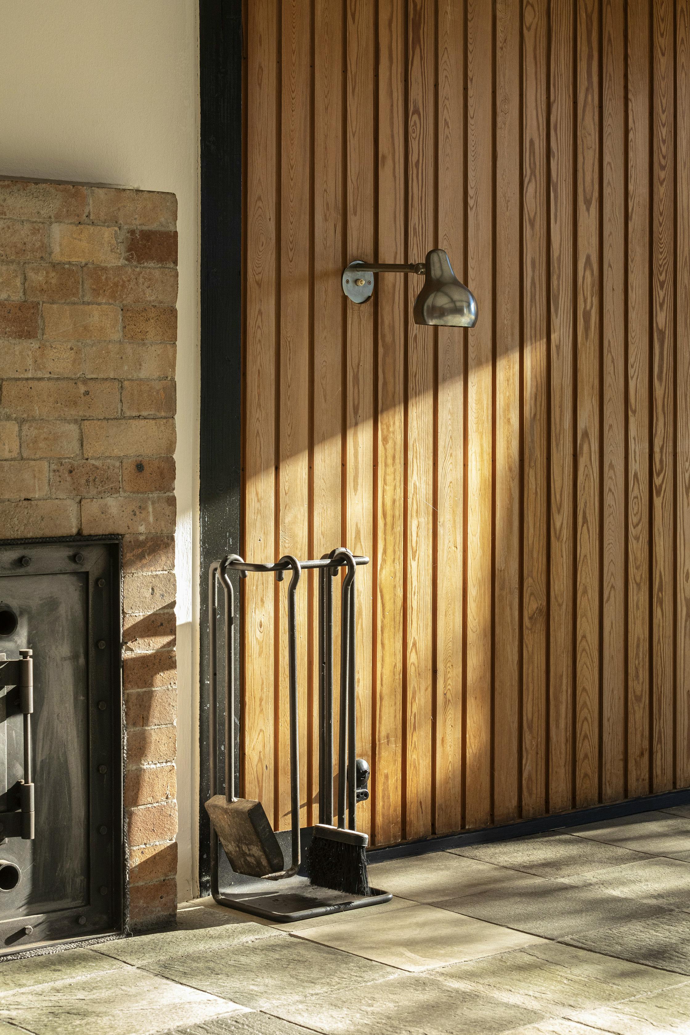 Muret pejs i gule mursten med det originale pejsesæt.