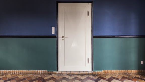 Spisestue i landsted tegnet af Kay Fisker med blå og grønne vægge samt klinkegulv i sildebensmønster.