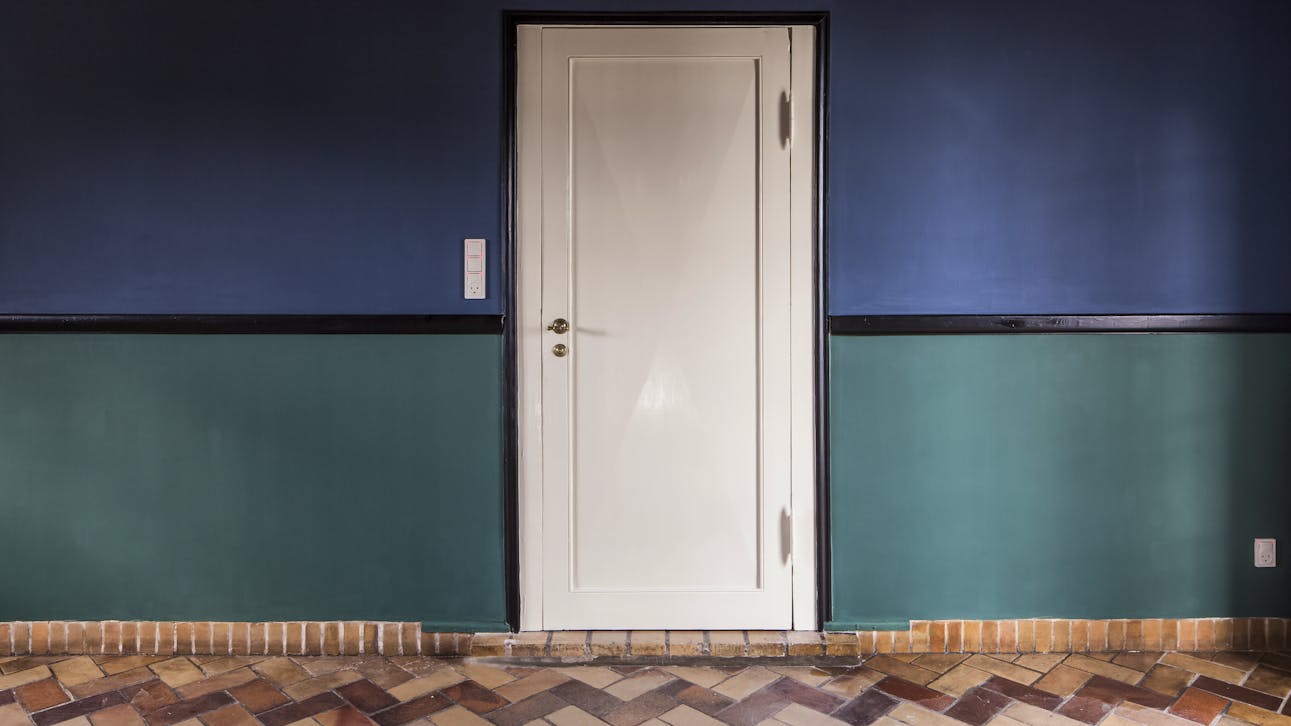 Spisestue i landsted tegnet af Kay Fisker med blå og grønne vægge samt klinkegulv i sildebensmønster.