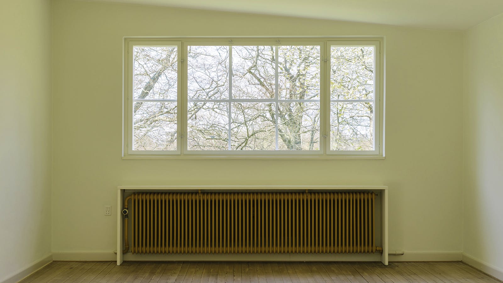 Atelier på første sal i Viggo Møller-Jensens eget hus med stort sprossevindue og gul radiator under.