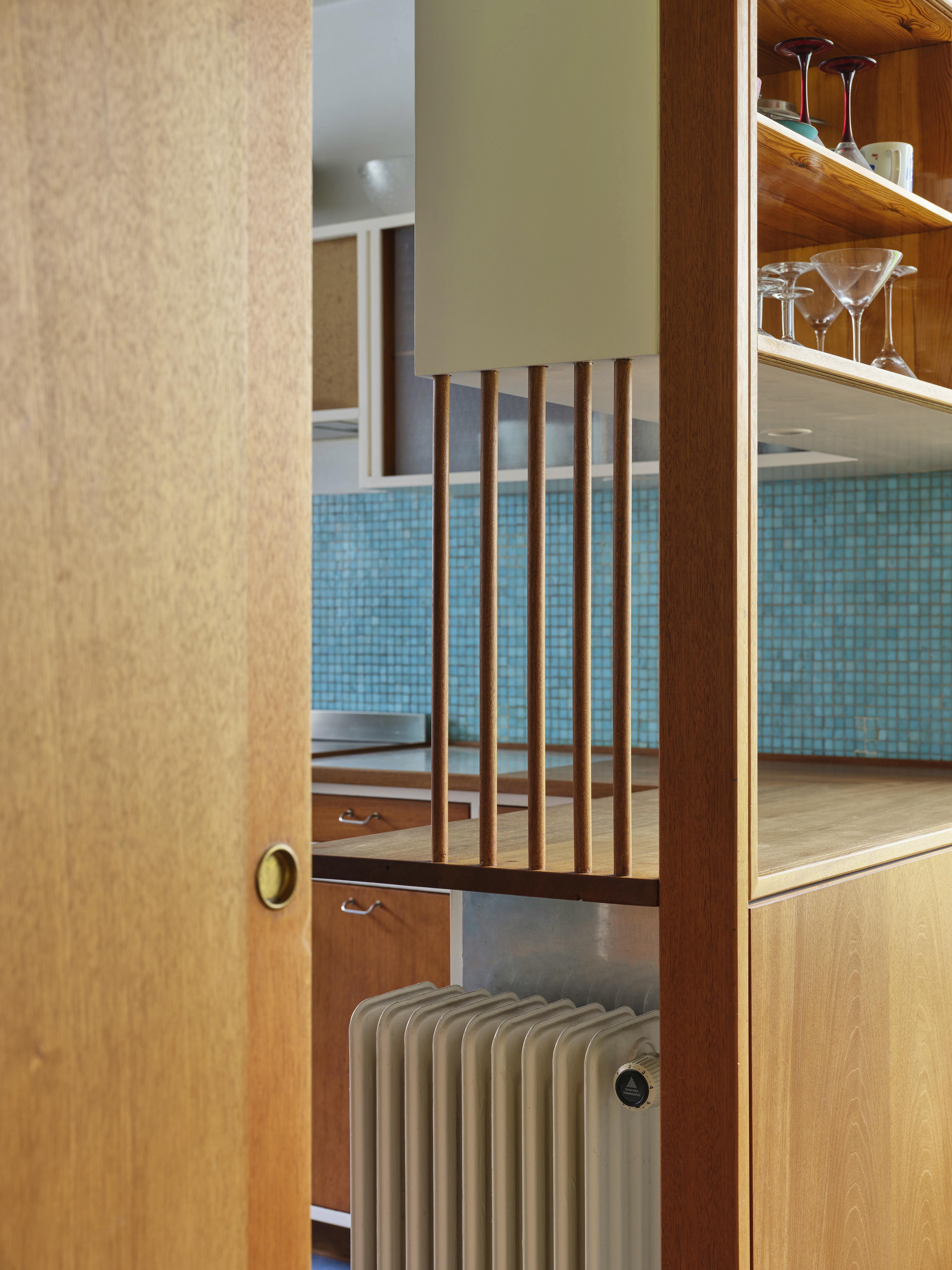 Overgangen mellem stue og køkken i Vilhelm Lauritzens eget hus – gennemtænkt detalje med varme træmaterialer og rumadskillelse.