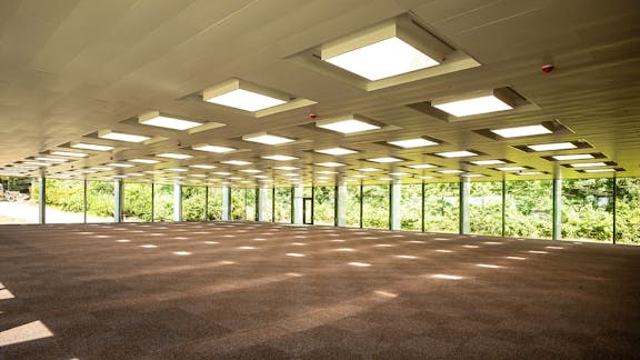 Storrum i Glasalstrup med modulært loft og gennemgående glasfacader – et lyst og åbent kontormiljø med udsigt til grønne omgivelser.