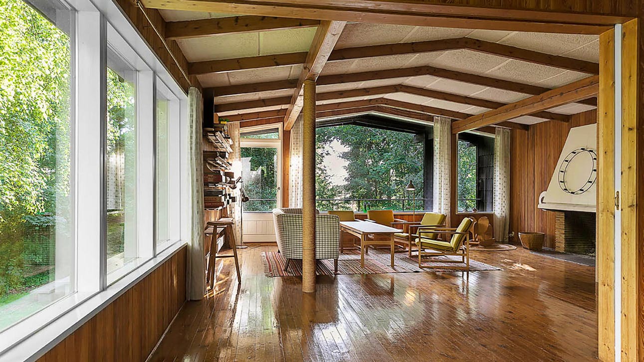 Stuen på første sal med pejs og et panoramavindue med et fantastisk kig til de frodige omgivelser.