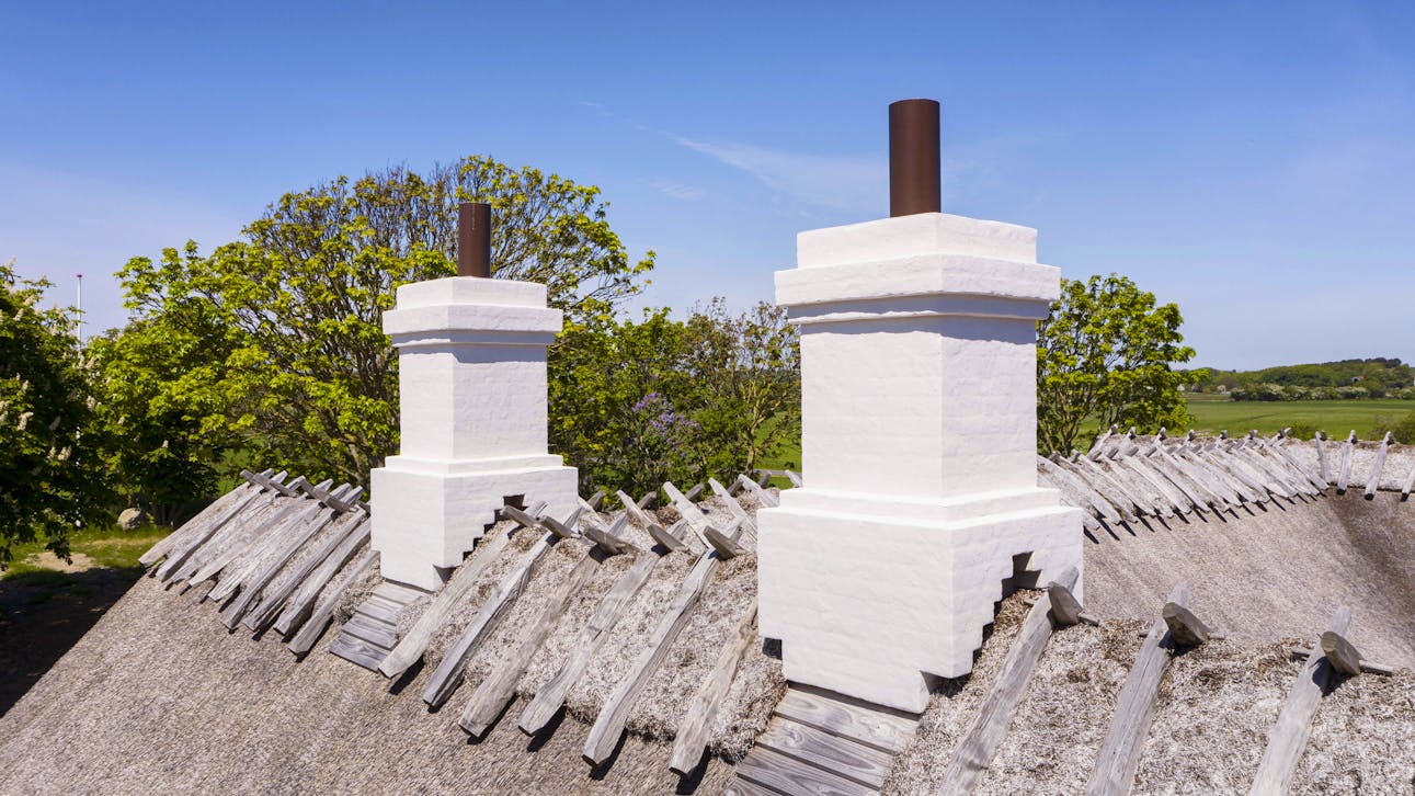 Skorstenene på Højgaarden er enkelt udformet og hvidkalkede med let profilerede gesimser.