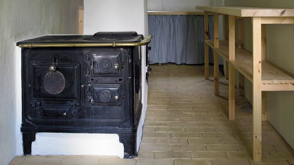 I køkkenet i Kalines tanghus på Læsø er det gamle støbejernsovn bevaret som et minde om husets historie, mens et nyt komfur også er installeret.