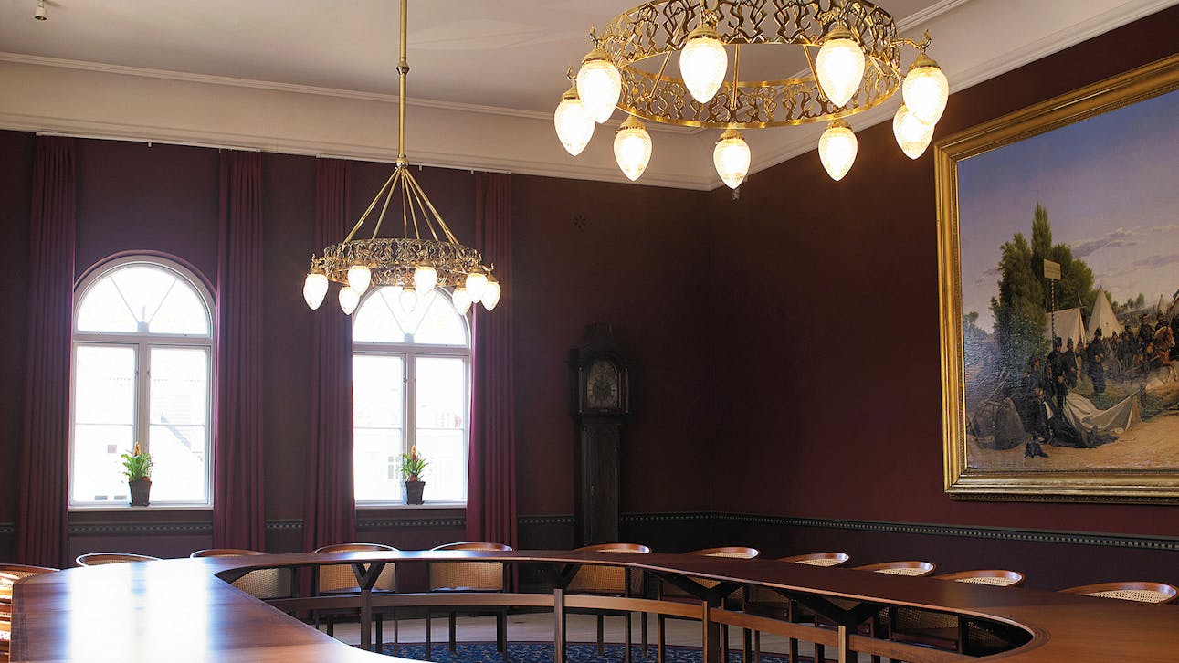 Byrådssalen. Efter restaureringen fremstår rummet nu igen i hele sin udstrækning, i de oprindelige farver og med de originale lysekroner.