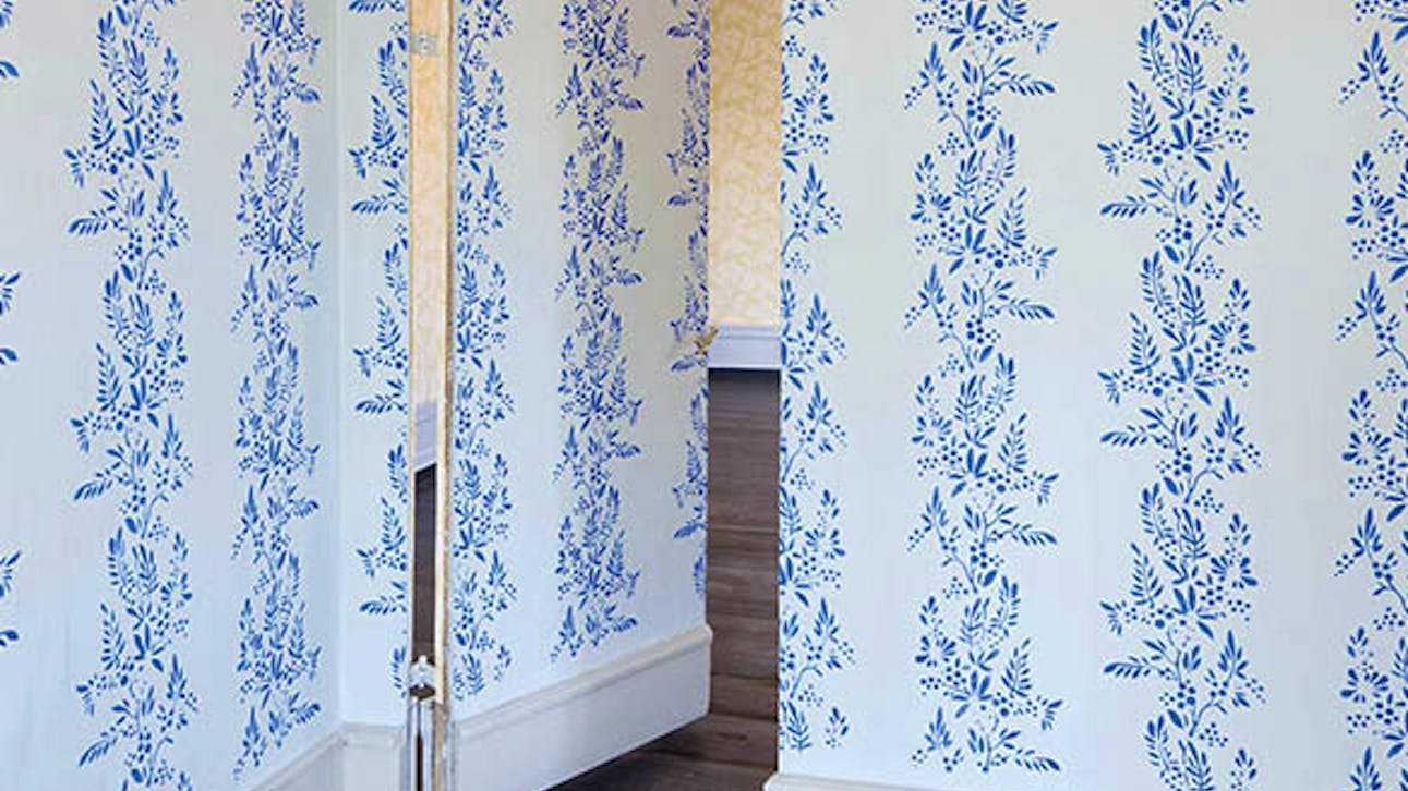 Den genskabte, malede tapet-illusion med et skjult dørparti.