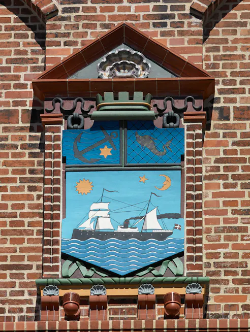 Byvåben med skibe og havmotiver på Ambergs Tinghus i Esbjerg.