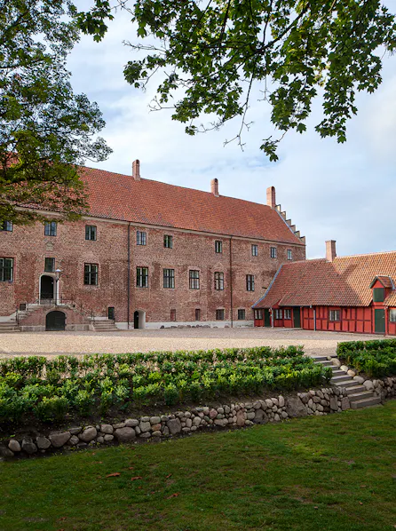Vinkelret på facaden ligger en bindingværksbygning fra 1745. Fløjen er tidligere domestikfløj men er nu indrettet med et auditorium og handicapadgang.