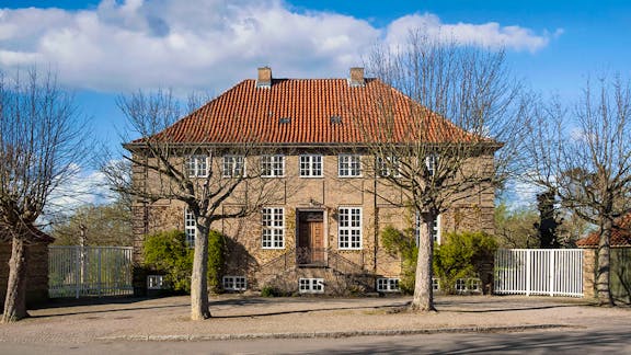 Grosserens villa ligger på toppen af vejen Bakkekammen med forplads og fire træer.