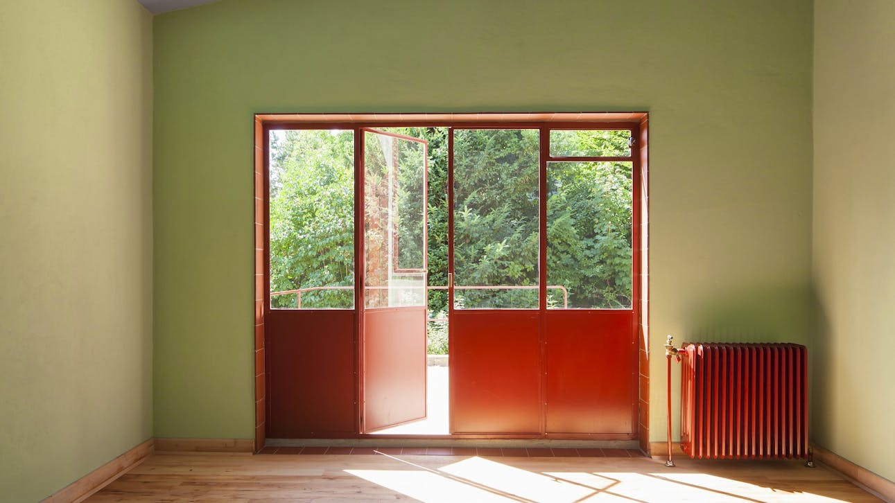 Gennem spisestuens røde dør- og vinduesparti er der adgang til terrassen.