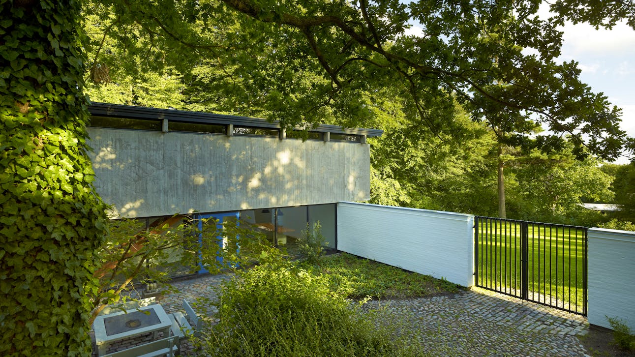 Gårdarealet er i forbindelse  med restaureringen eftergået  i belægninger og beplantning,  så det fremstår med sin oprindelige stramhed som en del af  arkitekturens helhed.