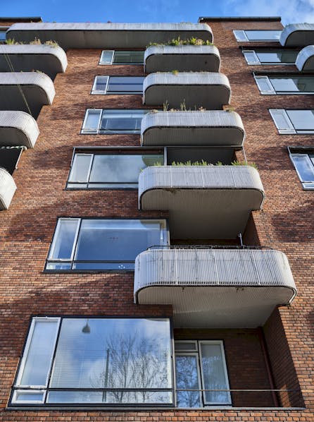 Et kig op ad facaden afslører de karakteristiske hvide altaner, der pryder bygningen ud mod Vester Søgade.