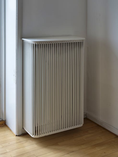 Lejlighedens mange radiatorer er dækket af originale radiatorskjulere, hvis tremmer mimer altan-værnet.
