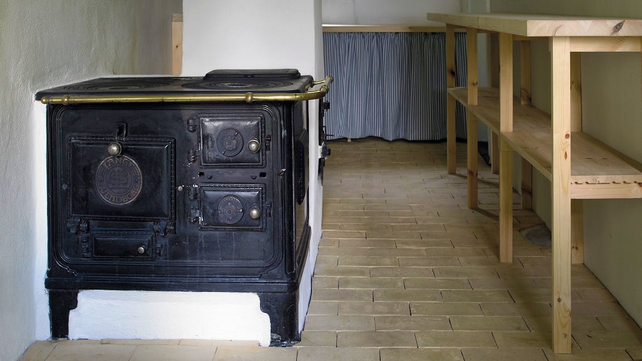 I køkkenet i Kalines tanghus på Læsø er det gamle støbejernsovn bevaret som et minde om husets historie, mens et nyt komfur også er installeret.